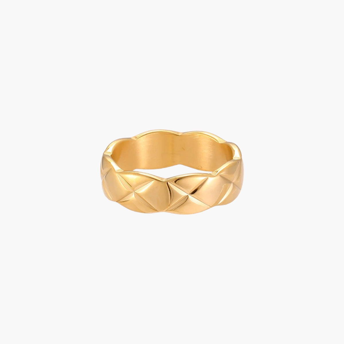 Close-up of an 18K gold-plated twisted band ring with dimensional braided pattern on cream background.